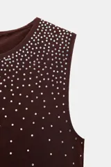 Top sin mangas, color azul marino, con cuello redondo y aplicación de brillos plateados que se dispersan desde el escote hacia el cuerpo.