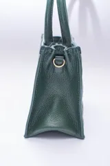 Cartera pequeña color beige, con diseño acolchado en forma de rombos. Tiene doble asa corta y correa larga desmontable y regulable.