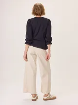 Pantalon de corte ancho y holgado, confeccionado en una mezcla de algodón, viscosa y lino. Presenta un diseño de tiro medio con bolsillos traseros y costuras visibles que recorren el largo de las piernas.