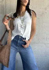 Musculosa blanca tejida con botones dorados en el lateral.