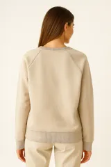 Sudadera negra de cuello redondo, manga larga tipo raglán y corte holgado.