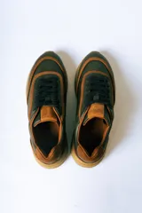 Championes de cuero en combinación de colores verde oliva y detalles en cuero color suela. Presentan cordones al tono y una suela de goma robusta en color suela con diseño dentado.