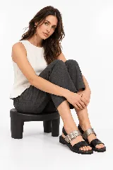 Sandalias de cuero color negro y plateado, con diseño de dos tiras anchas, hebilla metálica grande y suela baja con plataforma de 3 cm.