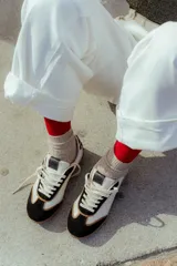 Zapatillas urbanas de cuero color beige y blanco con detalles en animal print en el talón y cordones marrones.