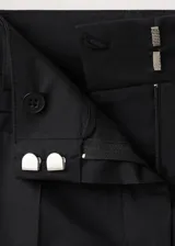 Pantalón de tiro bajo y diseño acampanado color negro, con trabillas para cinturón y bolsillos traseros ribeteados, confeccionado en mezcla de algodón elástico.