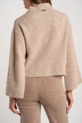 Sweater de punto acanalado color marrón, con cuello alto tipo polera y mangas largas de corte ancho. Posee un diseño oversize confeccionado en mezcla de lana.