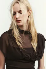 Vestido midi marrón con cuello alto y mangas cortas abullonadas. Presenta frunces en la parte superior y falda plisada. Incluye forro interior de tirantes finos ajustables y cierre lateral con cremallera oculta.