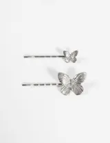 Set de dos horquillas plateadas para el pelo con aplique de mariposa metálica.
