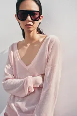 Jersey de punto fino negro con escote en V profundo y manga larga con puños ajustados.