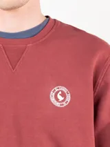 Buzo de felpa 100% algodón color bordó, de corte regular fit, con cuello redondo y manga larga. Presenta acabado lavado y logo estampado en el pecho.