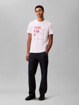 Remera blanca Calvin Klein de corte regular y manga corta, con cuello redondo y estampado gráfico de inspiración urbana en el pecho.