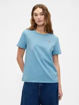 Remera azul de manga corta con cuello redondo y un pequeño oso bordado en el pecho.