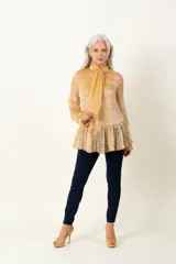 Blusa dorada de organza plisada con bordado de perlas, lazo en el cuello y musculosa debajo.