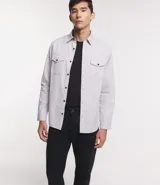 Camisa verde militar de manga larga en sarga de algodón, con cuello clásico, cierre frontal abotonado y dos bolsillos con solapa abotonada en el pecho.