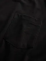 Remera negra de manga corta con cuello redondo y un bolsillo aplicado en el pecho.