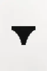 Tanga negro de tiro medio con cintura elástica y aplicación de encaje a tono en los bordes.