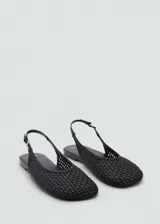 Zapato tipo slingback de color negro con diseño trenzado, punta redonda y cierre de tira con hebilla ajustable en el talón.