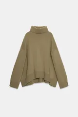 Jersey de corte oversize confeccionado en mezcla de lana, con cuello alto y manga larga. Presenta un diseño holgado con terminaciones en rib en el cuello, puños y ruedo.