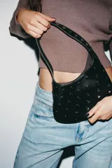 Bolso de hombro negro con tachas plateadas y tarjetero extraíble con cierre.