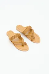 Sandalia plana de cuero negro con diseño de tiras trenzadas que cruzan el empeine y se sujetan entre los dedos. Presenta costuras decorativas en el borde de la plantilla y suela plana.