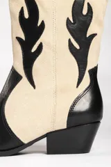 Bota estilo texana de gamuza color marrón, con diseño de apliques en forma de llamas en color crema y taco de madera.