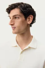 Remera polo de punto jacquard de mezcla de algodón, color blanco, de manga corta, con cuello clásico y tapeta corta de botones. Corte entallado.