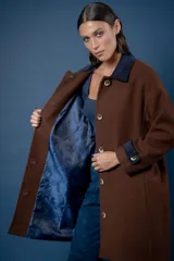 Tapado de corte recto con estampado de pata de gallo en tonos azul y gris. Presenta cuello camisero y detalles en los puños en color negro, cierre frontal con botones y bolsillos laterales.