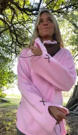 Sweater de tejido de punto suave en color rosado, con diseño holgado, cuello redondo y aberturas laterales en el ruedo.