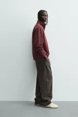 Sudadera roja de corte regular, con cuello alto y cierre frontal de cremallera. Manga larga y terminaciones en rib.