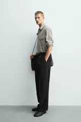 Camisa de corte relajado con estampado de cuadros, cuello solapa, manga larga con puños abotonados y bolsillos frontales de plastrón con solapa. Cierre frontal con botones a presión.