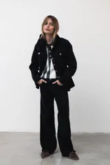 Chaqueta de denim de algodón con corte entallado en la cintura, cuello clásico, cierre frontal con botones metálicos y dos bolsillos con solapa en el pecho.