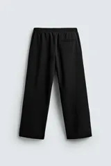 Pantalón relaxed fit color azul marino, confeccionado en tejido fluido con viscosa. Cuenta con cintura elástica ajustable con cordón interior, bolsillos laterales y bolsillos traseros de vivo. Las perneras tienen costura frontal y el bajo es ajustable con cremalleras laterales.