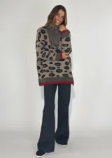 Sweater gris con estampado animal print en azul marino, cuello alto con cordón ajustable y puños y ruedo en color bordó.