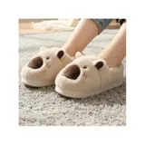 Pantuflas cerradas de peluche suave color beige, con diseño de capibara que incluye orejas y hocico marrón. Tienen suela antideslizante.