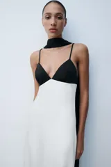 Vestido largo lencero con diseño bicolor en blanco y negro, escote en pico, tirantes finos ajustables, espalda descubierta y foulard incorporado a contraste.