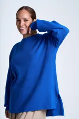 Sweater azul eléctrico de punto acanalado, con cuello redondo y mangas largas. Corte holgado con aberturas laterales.