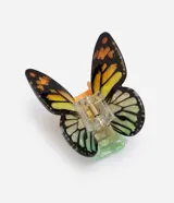 Pinza para el pelo con diseño de mariposa, fabricada en acrílico con detalles coloridos en tonos amarillos, verdes y negros en las alas.