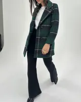 Saco de paño con estampado de cuadros en tonos verdes y negros, diseño de doble botonadura, solapas clásicas y bolsillos laterales.