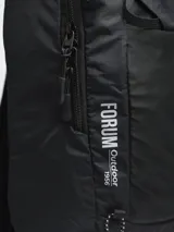 Mochila de trekking color negro, confeccionada en nylon ripstop. Cuenta con compartimento principal amplio, bolsillo frontal abierto, compartimento superior con cierre y pasadores exteriores para accesorios. Incluye tiras ajustables con broche frontal y cubre lluvia integrado.