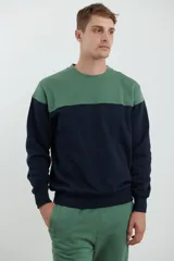 Sweater deportivo de hombre con escote redondo, diseño colorblock con la parte superior en gris claro y el cuerpo y mangas en negro. Presenta puños y cintura elastizados.