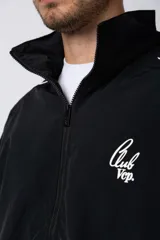 Campera deportiva negra con cierre frontal, capucha ajustable y detalles de líneas blancas en las mangas. Presenta el logo de la marca bordado en el pecho.