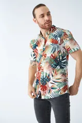 Camisa de manga corta con estampado botánico de hojas en tonos azul y blanco. Presenta cuello clásico, cierre frontal abotonado y corte slim.