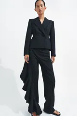 Blazer entallada de Zara, confeccionada en hilatura con lana. Presenta cuello solapa de muescas, manga larga con botones en puños, bolsillos de vivo en el delantero y cierre frontal cruzado con botones.