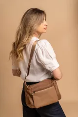 Bandolera de diseño práctico y moderno, confeccionada en una combinación de tela y cuero sintético. Cuenta con un compartimento principal con cierre, un bolsillo frontal con cierre y una correa regulable para llevar al hombro o cruzada.
