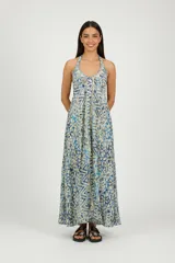 Vestido largo de poliéster con estampado batik en tonos azules y beige. Diseño halter con cuello profundo anudado y corte amplio.