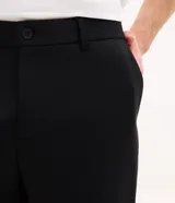 Pantalón de sastrería gris, de corte skinny y calce ajustado, con trabillas en la cintura, bolsillos laterales y cierre frontal con botón y cremallera. Confeccionado con tecnología performance que facilita el planchado y ofrece secado rápido.