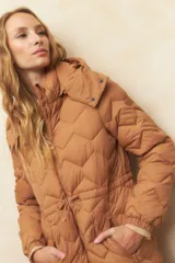 Campera larga color marrón con diseño acolchado, capucha desmontable, cierre frontal con botones a presión, bolsillos laterales con cierre, puños elásticos y cintura ajustable.