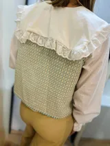 Chaleco con estampado geométrico en tonos turquesa y beige, con escote en V y lazo para ajustar en la parte delantera. Confeccionado en lino italiano reversible.