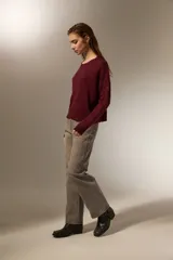 Sweater de punto negro con destellos de lurex, cuello redondo a la base y mangas largas con puños ajustados.