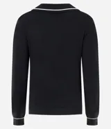 Blusa femenina de punto color blanco crema, con cuello polo y escote en V. Presenta detalles de biés negro contrastante en el cuello y los puños de las mangas largas.